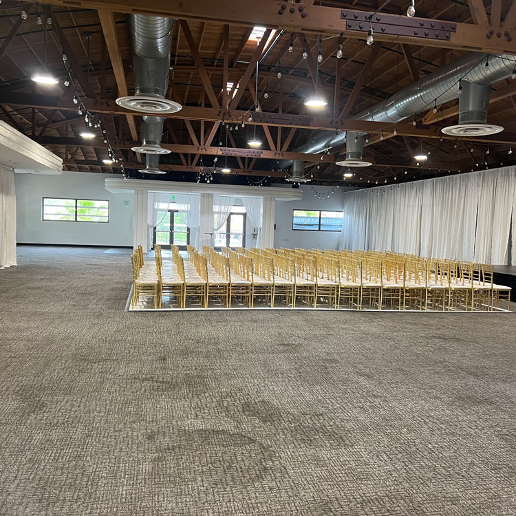 Large event hall with gold chairs and carpet