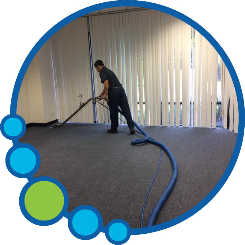Person cleaning carpet with a professional carpet cleaning machine near vertical blinds